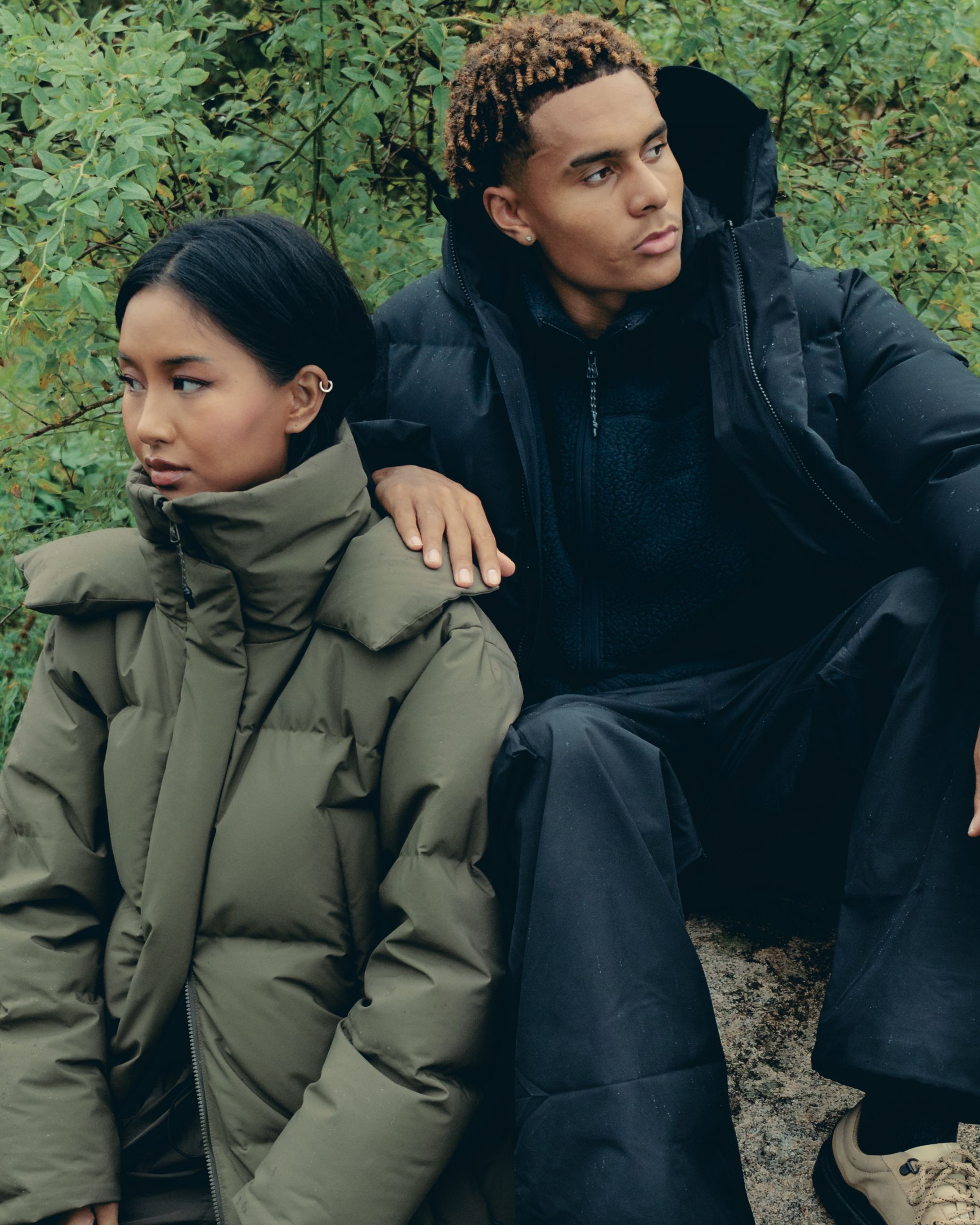 Man wearing the Ulla down jacket from BLÆST, with a woman wearing the Stranda down jacket from BLÆST